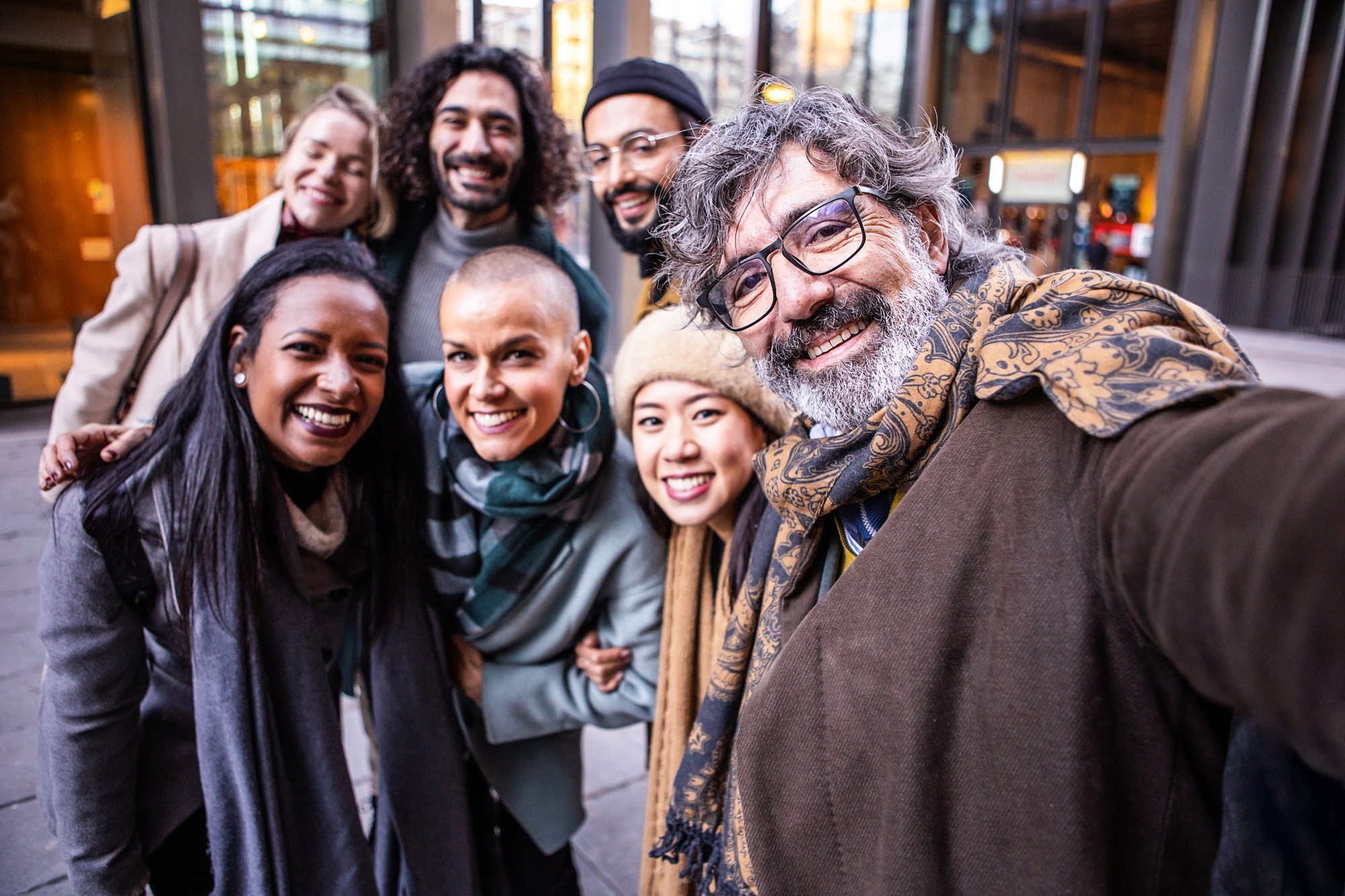 Happy coworkers taking a selfie together outdoors.